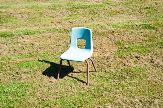 Empty child’s chair in a field