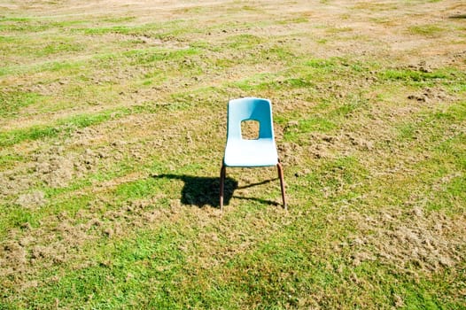 Empty child’s chair in a field