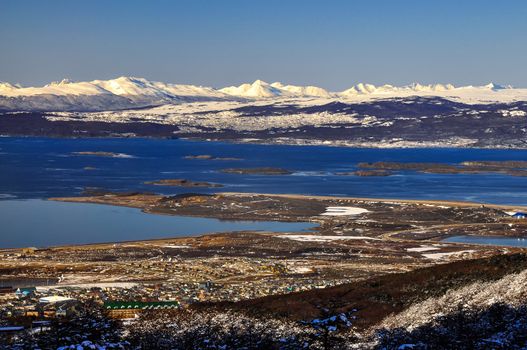 Ushuaia with the Beagle Channel and snow covered mountains behind it.