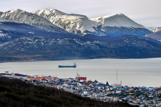 A view of Ushuaia with snowy mountains behind it.