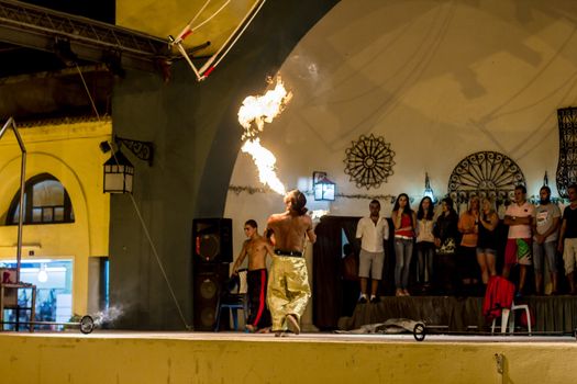 Spectacular show at an outdoor stage in Hammamet, Tunisia, where Local talent showcase their extraordinary ability to breathe fire like the mystical fire breathing dragons.