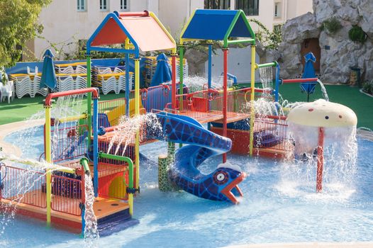 A playground with splashing water and a water slide