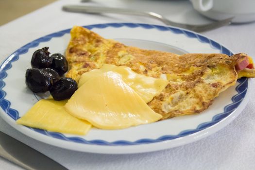 A tasty breakfast with an omelette, cheese and side of dates