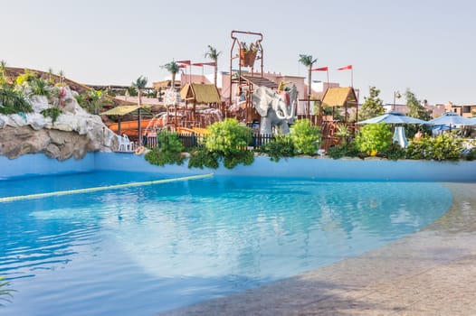 A clear blue swimming pool in a beautiful surrounded by plants