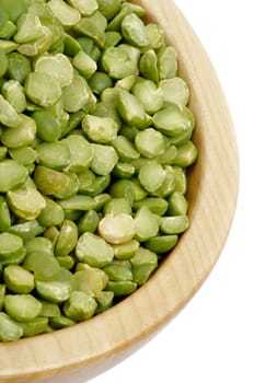 Green Split Peas in Wooden Bowl closeup on white background