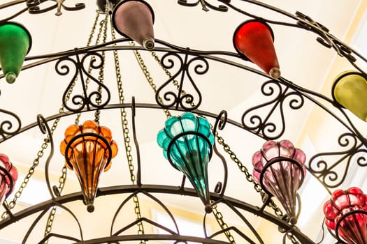 Beautiful chandelier comprised of several colorful ornaments and beautifully designed metal frame