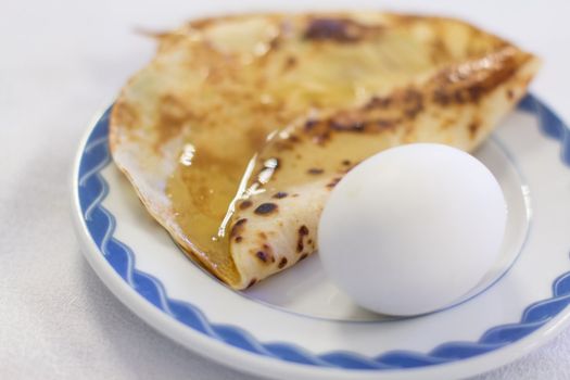 Breakfast comprising of boiled eggs and pancake drenched with syrup