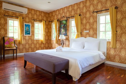 Hotel room in a tropical resort with bed and wooden flooring