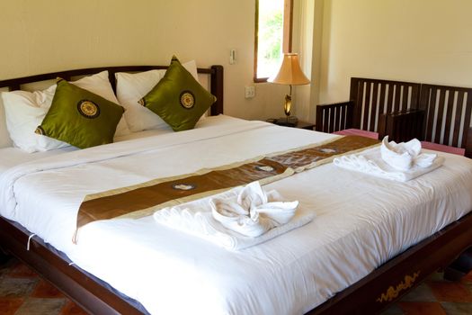 Hotel room in a tropical resort with bed and wooden flooring