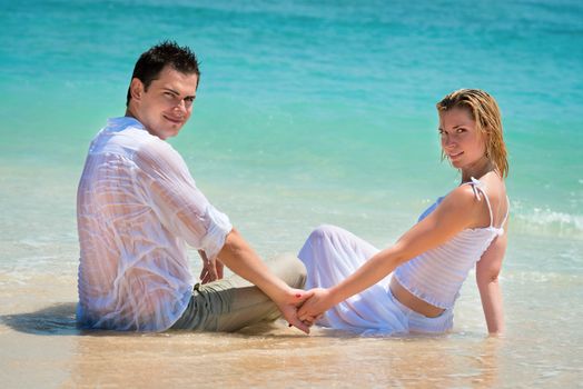 Young couple enjoying their holiday on the beach on blue tropical beach