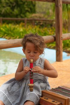 Cute girl in a  park playing with vintage instruments