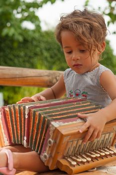 Cute girl playing with a vintage accordion