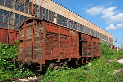 Vintage industrial building and old wooden wagon
