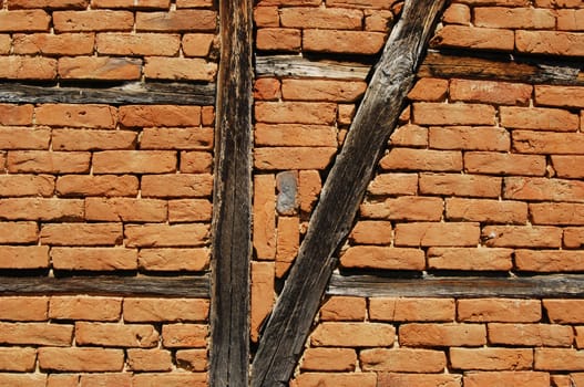 Old frame-build half-timbered red bricks barn's wall horizontal