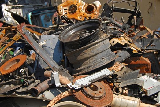 Scrap heap of used automobile parts as background