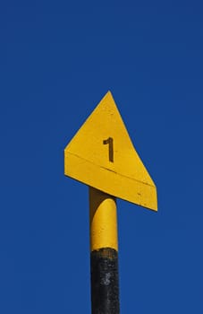 Yellow triangular path marker on blue-sky background