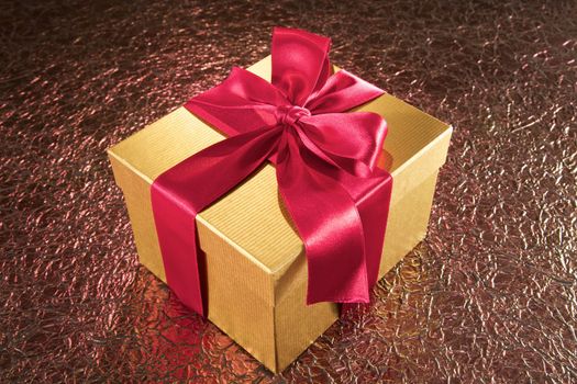 golden gift box on textured sparkling background
