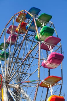 Brightly colored Ferris wheel against the blue sky