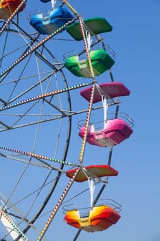 Brightly colored Ferris wheel against the blue sky