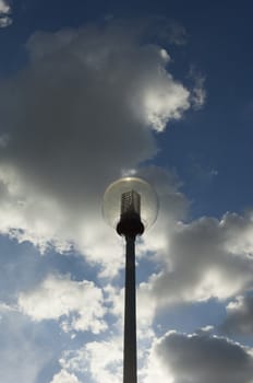 Modern spherical street light against a cloudy dramatic blue sky