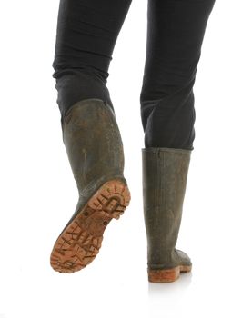muddy boots - woman walking away with muddy boots on white background