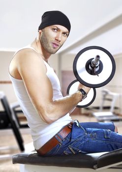 man makes exercises with bar in exercise room