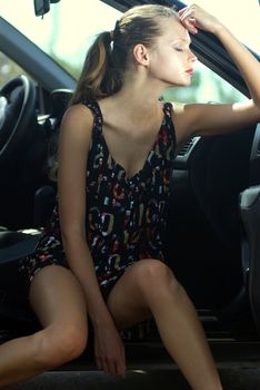 fashionable young beautiful sad woman in a car