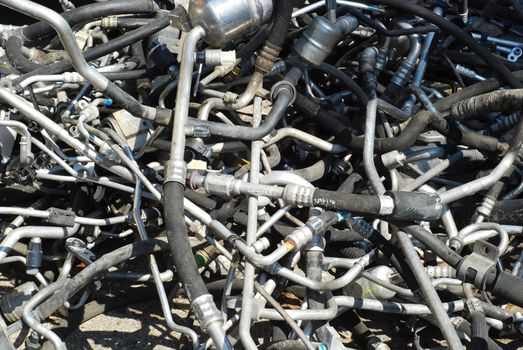 Automobile scrap heap used pipework closeup as background