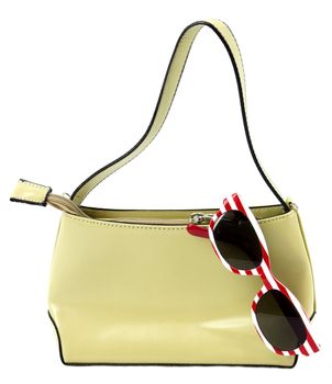 Purse with striped sunglasses on white background