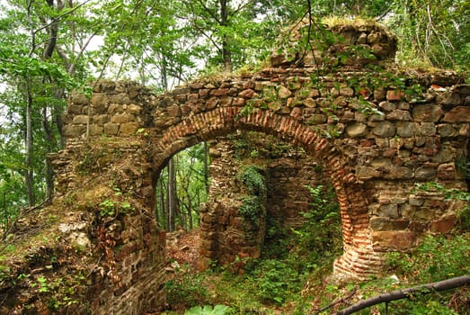 Ancient roman Balkan fortress arch gate, wall ruins in forest