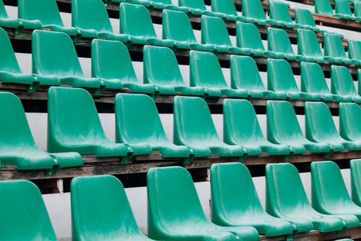 Green plastic old chairs in stadium