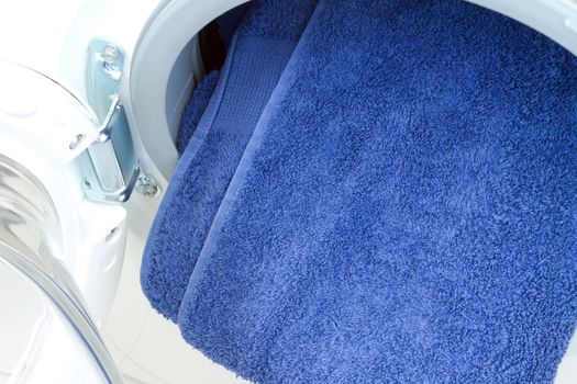 Open washing machine with  blue towel
