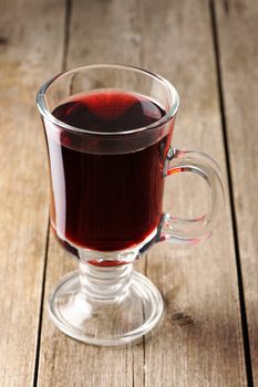 Glass of red mulled wine on wooden table