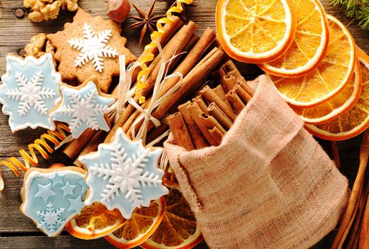 Christmas homemade gingerbread cookie and spices over wooden table