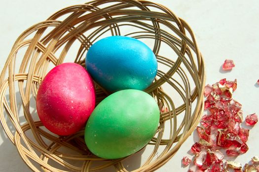 easter basket with easter eggs on wooden background