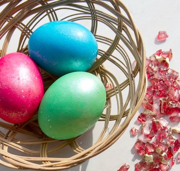 easter basket with easter eggs on wooden background