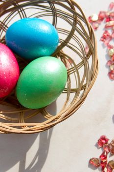 easter basket with easter eggs on wooden background