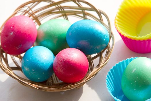 easter basket with easter eggs on wooden background