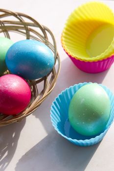 easter basket with easter eggs on wooden background