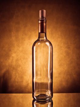Empty wine bottle on reflective surface against grunge background