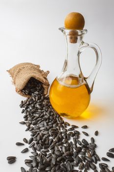 sunflower seeds and vegetable oil in a bottle on a white background