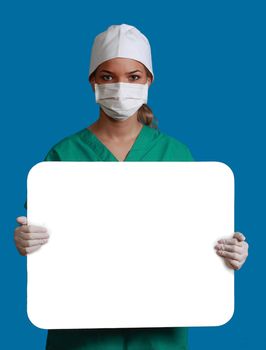 A young woman doctor in a mask holding an empty bill board against a blue background.