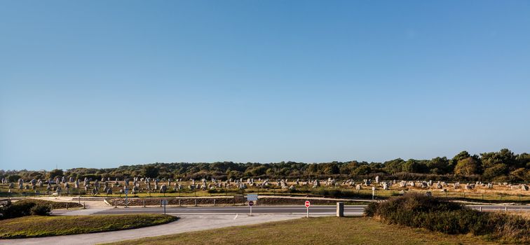 Panoramic view of the Menec Alignments near the roads in Carnac area in Brittany in north-western France. Menec Alignments are  a part of the impressive Neolithic menhir collections which are presented in this area. 