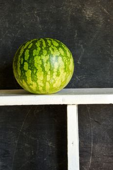 one watermelon on wooden shelf