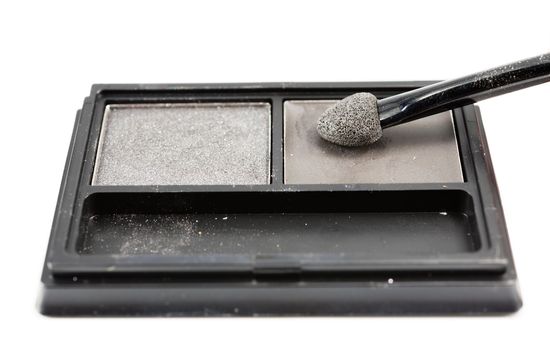 brush on eye shadows in black container on white background isolated