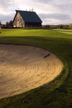 A raked sandtrap on a rural golf course