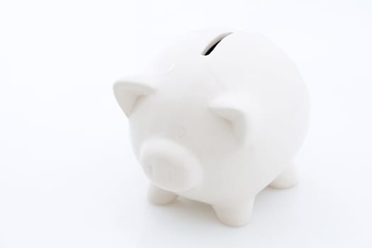 White piggy bank money box isolated on a white studio background.