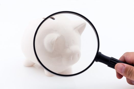 Piggy bank money box. Let's look at the economy with magnifying lens