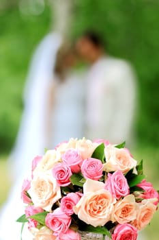 Wedding bouquet on the background of bride and groom