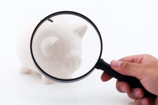 Piggy bank money box. Let's look at the economy with magnifying lens